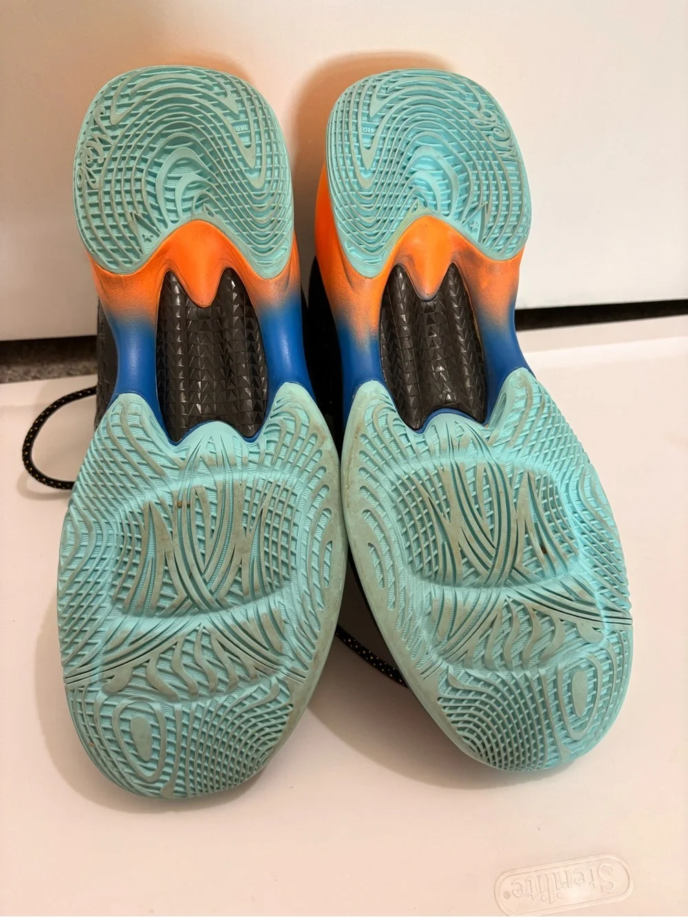 Jordan Melos Mens Black High-Top Sneakers with Orange Heel and Teal Sole